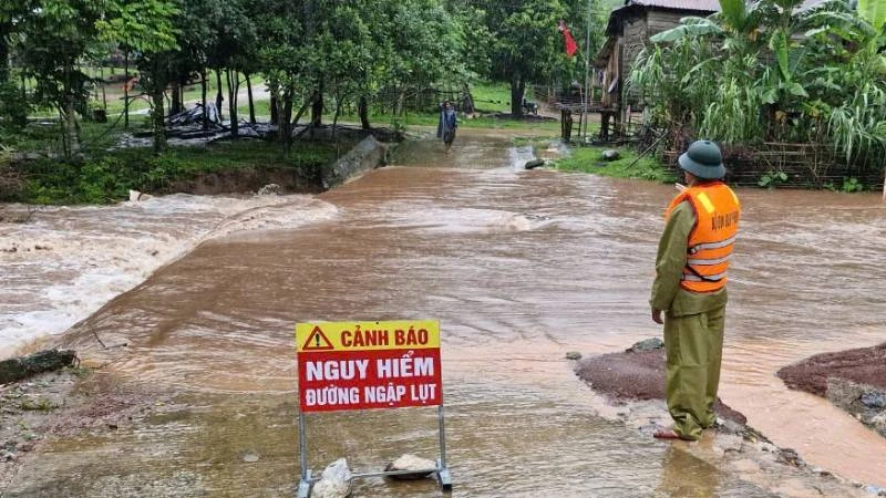 Một tuyến đường ở xã Thượng Trạch, huyện Bố Trạch bị ngập sâu, lực lượng chức năng đặt biển cảnh báo và chốt trực không cho người qua lại.