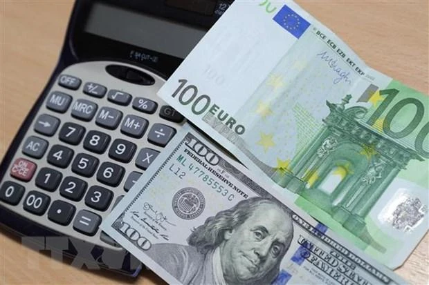 Đồng euro (phía trên) và đồng USD tại Brussels, Bỉ. (Ảnh: THX/TTXVN)