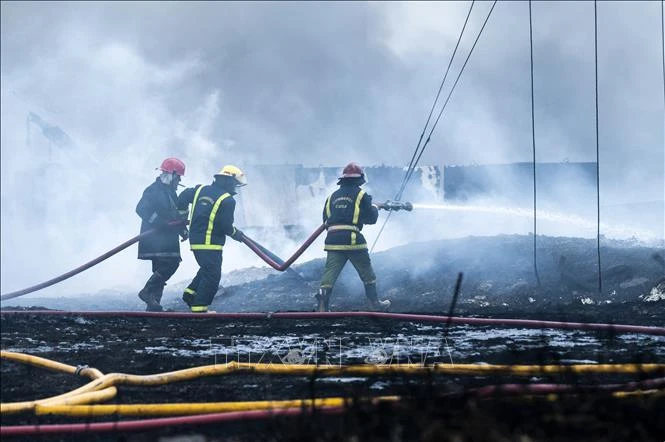 Lính cứu hoả nỗ lực dập lửa tại hiện trường vụ cháy kho chứa nhiên liệu lớn nhất Cuba trên Vịnh Matanzas, ngày 9/8/2022. (Ảnh: AFP/TTXVN)