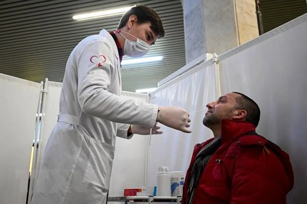 Nhân viên y tế lấy mẫu xét nghiệm Covid-19 cho người dân tại Moskva, Nga. (Ảnh: AFP/TTXVN)