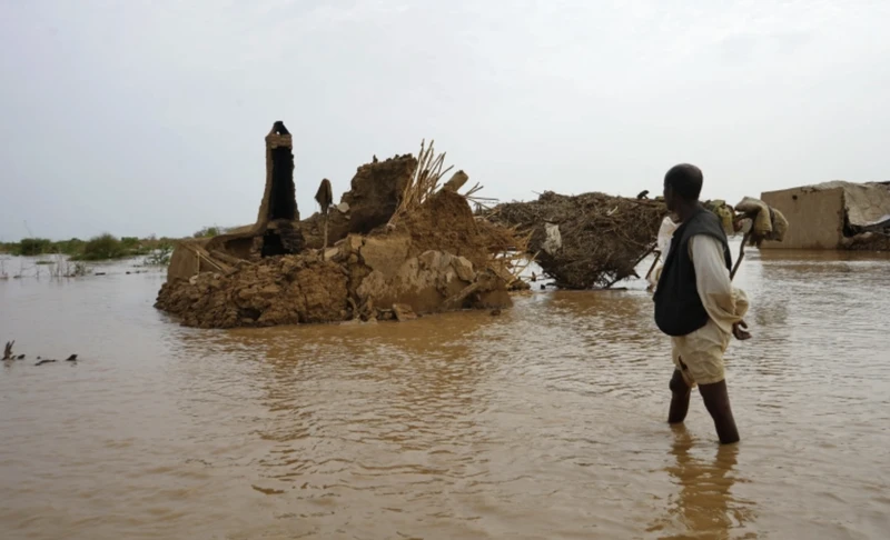 Một người dân lội qua khu vực bị ngập lụt ở Kassala, Sudan, ngày 18/8/2022. (Ảnh: AFP)