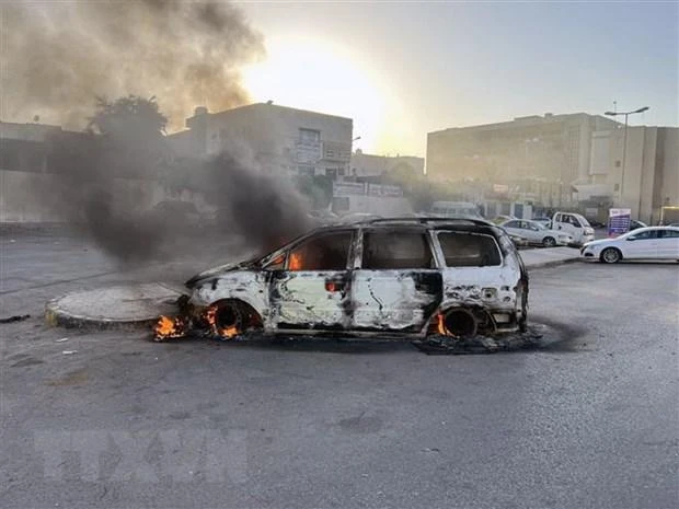 Ô-tô bị đốt cháy trong các vụ đụng độ tại Tripoli, Libya, ngày 27/8/2022. (Ảnh: THX/TTXVN)