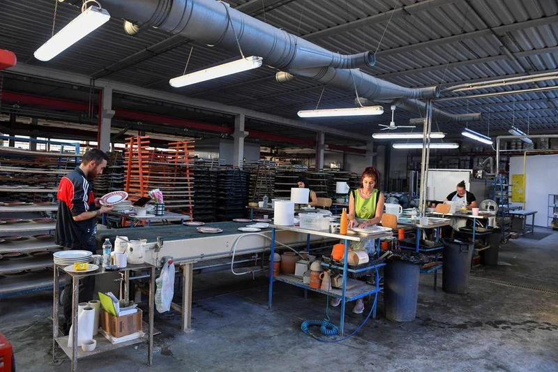Nhân viên nhà máy gốm sứ Ceramiche Noi, ở Citta di Castello, Italia bắt đầu ca làm việc từ sáng sớm để tận dụng thời tiết mát mẻ và tránh phải sử dụng nhiều năng lượng làm mát trong mùa hè oi bức. (Ảnh: Reuters)