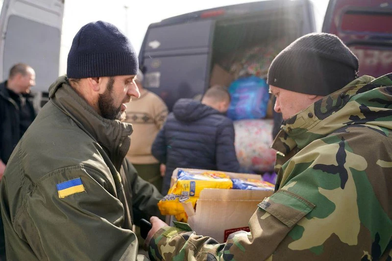 Lực lượng biên phòng Ukraine giúp chuyển hàng viện trợ nhân đạo từ Ba Lan cho những người di tản Ukraine ở Shehyni, Ukraine, ngày 27/2/2022. (Ảnh: Reuters)