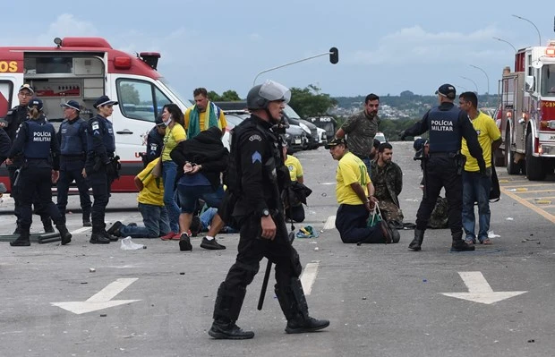 Lực lượng an ninh Brazil bắt giữ các đối tượng biểu tình đột nhập vào Dinh Tổng thống tại Brasilia, ngày 8/1/2023. (Ảnh: AFP/TTXVN)