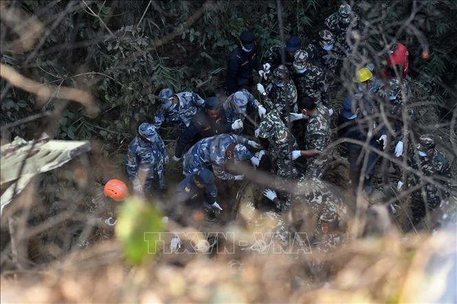Lực lượng cứu hộ tìm kiếm nạn nhân tại hiện trường vụ rơi máy bay ở thị trấn Pokhara, miền trung Nepal ngày 15/1/2023. (Ảnh: AFP/TTXVN)