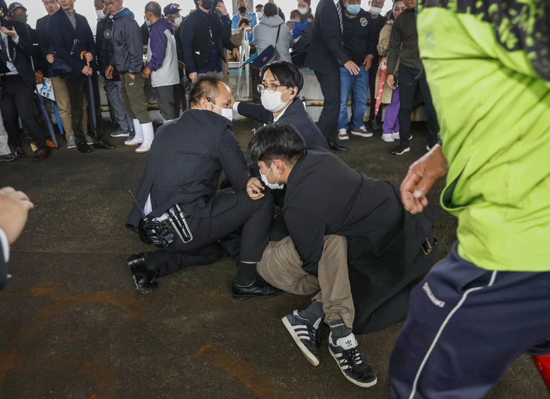 Một người đàn ông, được cho là nghi phạm ném bom khói về phía Thủ tướng Nhật Bản Fumio Kishida, bị cảnh sát khống chế tại cảng cá Saikazaki ở Wakayama, tỉnh Wakayama, tây nam Nhật Bản, ngày 15/4/2023. (Ảnh: Kyodo/Reuters)