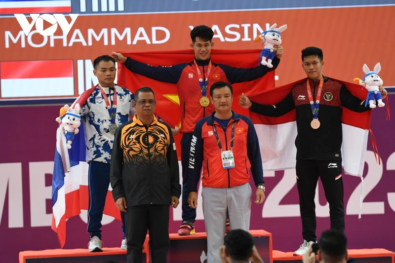 Vận động viên Trần Minh Trí (giữa) trên bục nhận Huy chương Vàng hạng cân 67kg nam. (Ảnh: VOV)