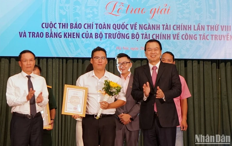 Thứ trưởng Tài chính Nguyễn Đức Chi và Phó Chủ tịch Thường trực Hội Nhà báo Việt Nam Nguyễn Đức Lợi trao giải A cho đại diện nhóm tác giả của Báo Nhân Dân. (Ảnh: TRUNG HƯNG)