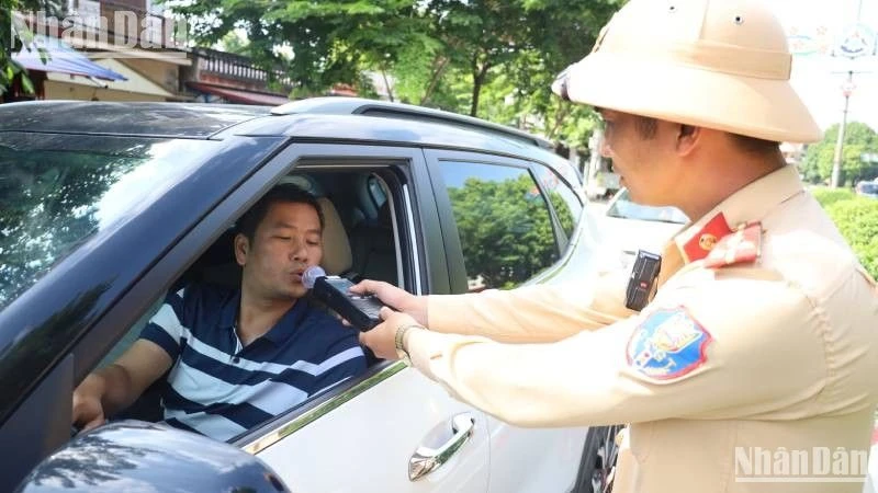 Lực lượng cảnh sát giao thông tỉnh Lạng Sơn thực hiện kiểm tra nồng độ cồn với các phương tiện lưu thông trên tuyến đường. (Ảnh: Báo Nhân Dân)