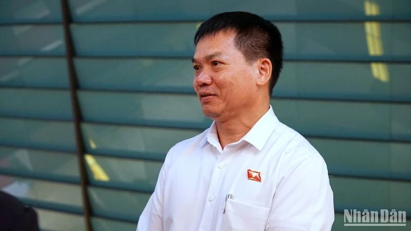 Đại biểu Dương Khắc Mai (Đoàn đại biểu Quốc hội tỉnh Đắc Nông) trao đổi bên hành lang Quốc hội. (Ảnh: TRUNG HƯNG)