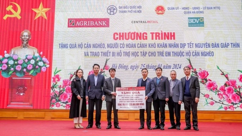 Đồng chí Phạm Đức Ấn - Bí thư Đảng ủy, Chủ tịch HĐTV Agribank trao tặng quà của Agribank hỗ trợ hộ cận nghèo, đối tượng chính sách quận Hà Đông (Hà Nội) nhân dịp Tết Nguyên đán Giáp Thìn.