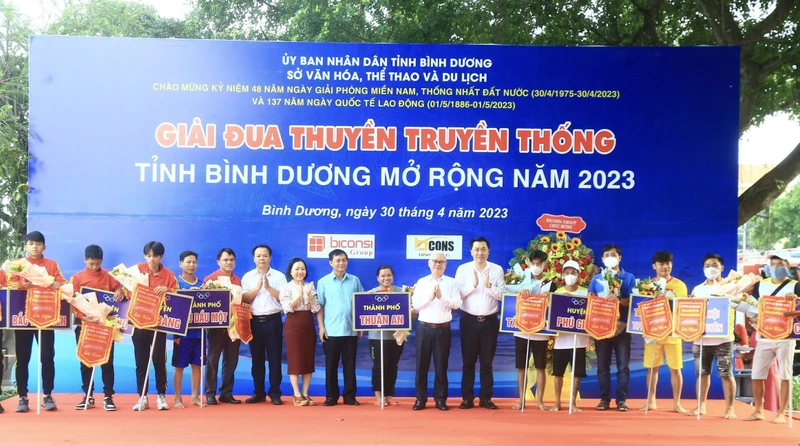 Bí thư Tỉnh ủy Bình Dương Nguyễn Văn Lợi và các đại biểu trao cờ lưu niệm và hoa cho các đội tham dự Giải đua thuyền.