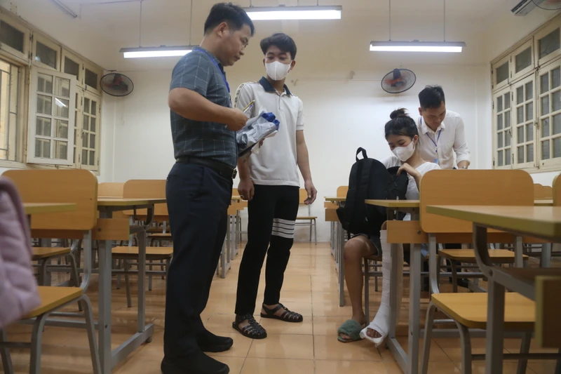 Tình nguyện viên và các giám thị hỗ trợ thí sinh Trần Thị Thu Hà tại điểm thi trường Trung học phổ thông chuyên Nguyễn Huệ (Hà Đông).