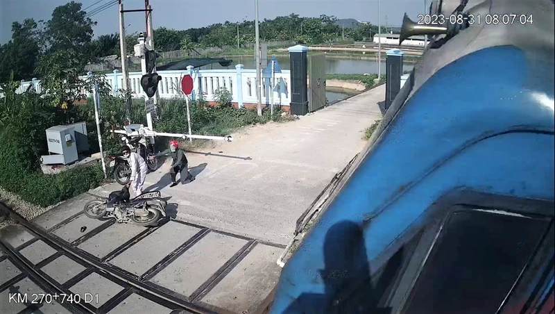 Nữ công nhân thông tin đường sắt Phạm Thị Hường cứu người thoát tai nạn tàu đâm trong gang tấc tại Diễn Châu (Nghệ An) vào sáng qua (Ảnh trích xuất camera giám sát đường ngang).