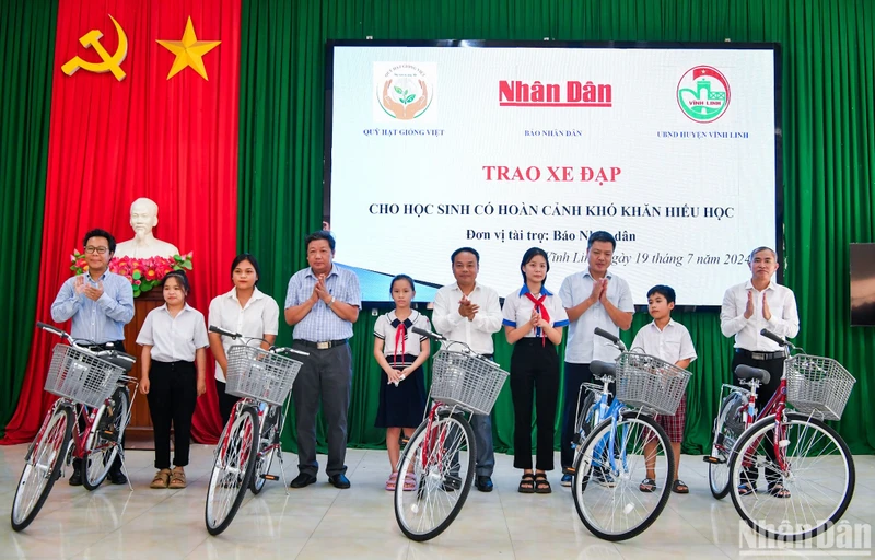 Đồng chí Đinh Như Hoan, Phó Tổng Biên tập Báo Nhân Dân trao tặng xe đạp cho học sinh có hoàn cảnh khó khăn hiếu học tại huyện Vĩnh Linh. (Ảnh: THÀNH ĐẠT)