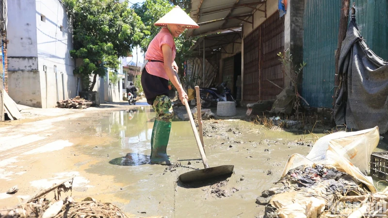 Người dân xã Nam Phương Tiến dọn dẹp lại nhà cửa sau đợt ngập lụt kéo dài.