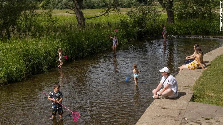 Các gia đình tắm mát ở sông Darent ở Eynsford, Anh. (Ảnh: CNN)