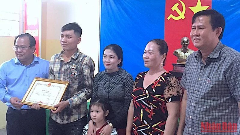 Phó Chủ tịch UBND tỉnh Cà Mau Nguyễn Minh Luân (bìa trái) trao Bằng khen của lãnh đạo tỉnh cho tài xế Phong. 