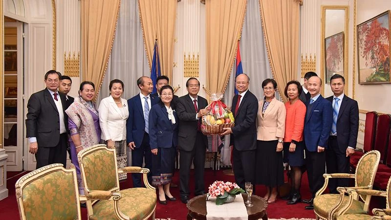 Đại sứ Việt Nam tại Pháp Đinh Toàn Thắng tặng hoa chúc mừng Quốc khánh nước Cộng hòa dân chủ nhân dân Lào. (Ảnh: MINH DUY)