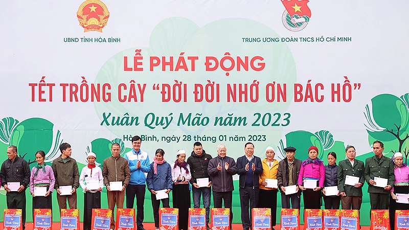 Các đồng chí Đỗ Văn Chiến, Nguyễn Phi Long, Bùi Quang Huy (lần lượt thứ 9, 8 và 13 từ phải sang) trao quà tặng đại diện các gia đình chính sách, hộ dân có hoàn cảnh khó khăn tại buổi lễ.