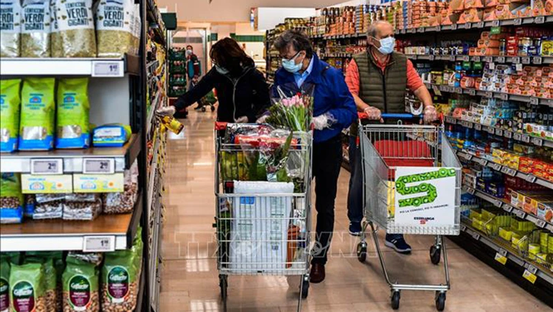 Người dân mua hàng trong siêu thị ở thành phố Milan, Italia. (Ảnh: AFP/TTXVN)