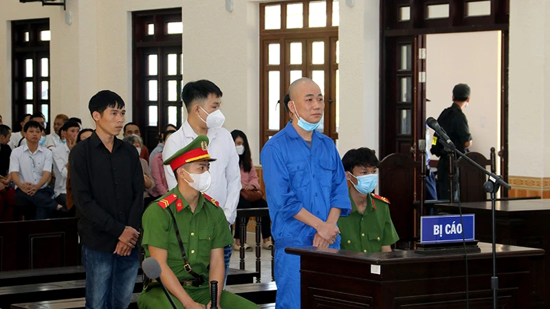 Bị cáo Phạm Văn Nam (đứng trước) và ba bị cáo: Trần Quốc Phong, Nguyễn Thiện Khiêm và Võ Lam Trường (đứng hàng sau) tại phiên tòa.