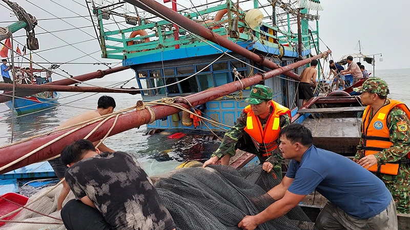 Bộ đội Biên phòng giúp ngư dân trên tàu cá bị chìm đưa ngư lưới cụ vào bờ.