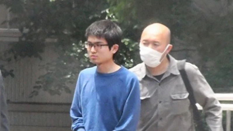 Cảnh sát áp giải đối tượng Nao Sato (áo xanh). (Nguồn: Asahi)