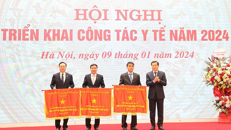 Phó Thủ tướng Chính phủ Lê Minh Khái trao Cờ thi đua của Chính phủ tặng ba tập thể thuộc Bộ Y tế.