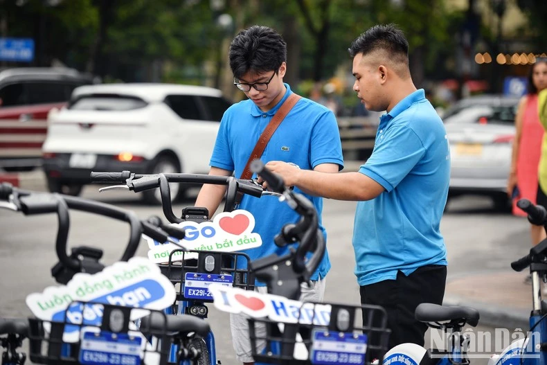 Người dân trải nghiệm dịch vụ xe đạp công cộng trong ngày đầu tiên hoạt động. (Ảnh: Thành Đạt).