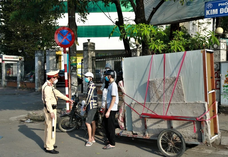 Cảnh sát giao thông kiểm tra, xử lý xe tự chế chở hàng cồng kềnh gây mất an toàn giao thông tại khu vực phố Kim Đồng (quận Hoàng Mai, Hà Nội).
