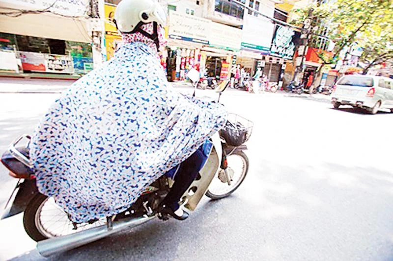 Trùm kín trong nhiều lớp trang phục chống nắng tiềm ẩn nguy cơ mất an toàn giao thông. Ảnh | MAI THU
