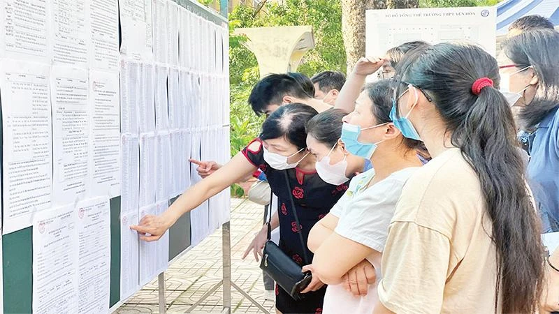 Cha mẹ và học sinh tìm hiểu thông tin nhập học lớp 10 tại Trường trung học phổ thông Yên Hòa. (Ảnh NGUYỄN HOÀI)