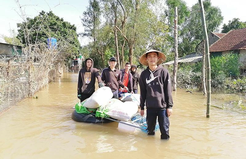 Sinh viên Lào hỗ trợ người dân huyện Cẩm Xuyên (Hà Tĩnh) khắc phục hậu quả thiên tai.