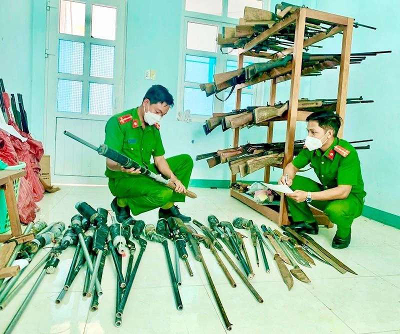 Công an huyện Ngọc Hồi, tỉnh Kon Tum kiểm tra vũ khí, công cụ hỗ trợ do người dân giao nộp. (Ảnh BẢO CHÂU)