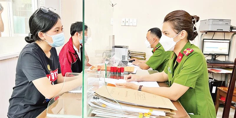 Cán bộ Công an phường Tân Chánh Hiệp, quận 12 giải quyết thủ tục hành chính cho người dân.