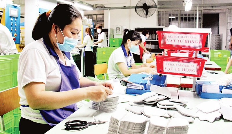 Công nhân Công ty cổ phần Giày Thiên Lộc (Quận 12) hoàn thiện sản phẩm. (Ảnh THẾ ANH)