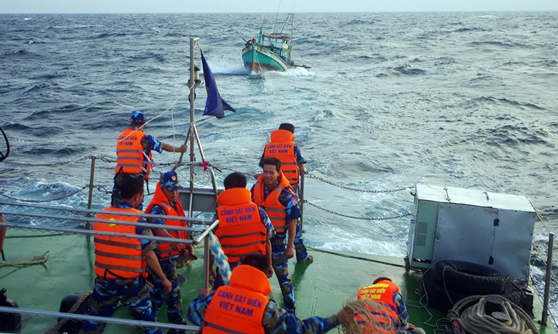 Cán bộ, chiến sĩ Bộ Tư lệnh Vùng Cảnh sát biển 4 hỗ trợ kéo tàu cá ngư dân gặp nạn vào bờ.