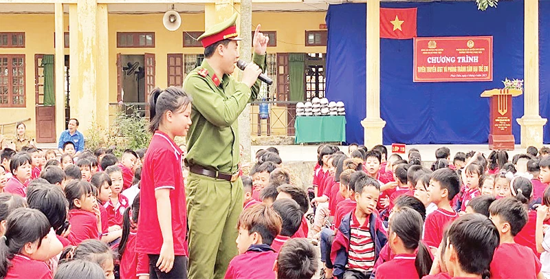 Đại úy Lương Văn Kiên tuyên truyền an toàn giao thông cho các em học sinh.
