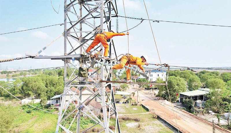 Công nhân Công ty Điện lực Quảng Bình đội nắng thi công đường dây điện 100kV. 
