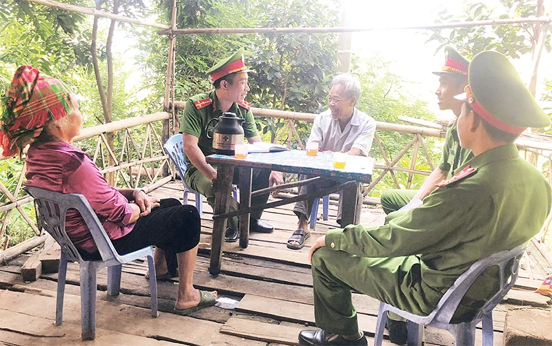 Cán bộ, chiến sĩ Công an xã Túc Đán, huyện Trạm Tấu trao đổi thông tin bảo đảm an ninh - trật tự với người dân bản Pa Khoang.