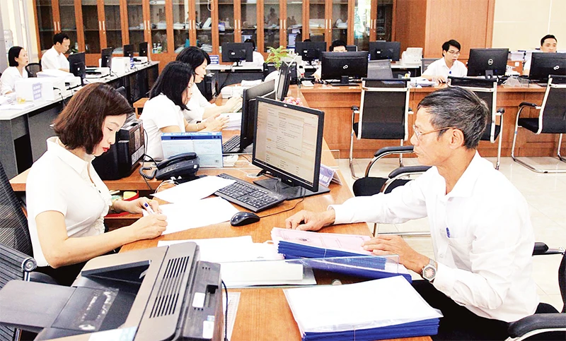 Cán bộ Trung tâm hành chính công tỉnh Thái Bình hỗ trợ người dân giải quyết thủ tục hành chính. (Ảnh THẾ DUYỆT) 