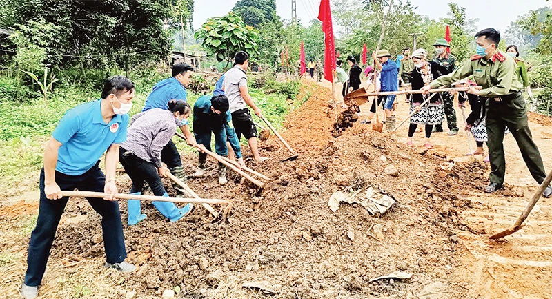 Cán bộ các cơ quan tỉnh Tuyên Quang giúp dân làm đường giao thông.