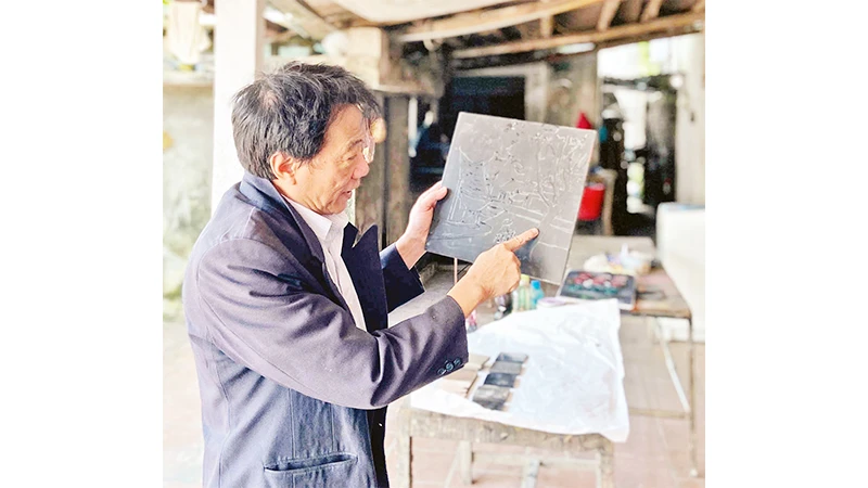 Nghệ nhân Vũ Huy Mến giới thiệu về kỹ thuật làm vóc sơn mài truyền thống.
