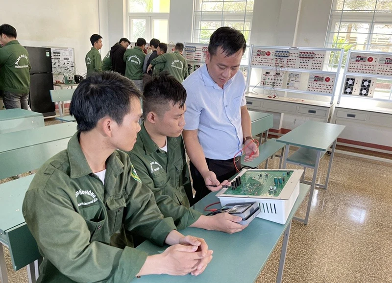 Thầy giáo Trường cao đẳng Nghề số 21 (Binh đoàn 15-Bộ Quốc phòng) hướng dẫn thực hành cho học viên lớp điện dân dụng.