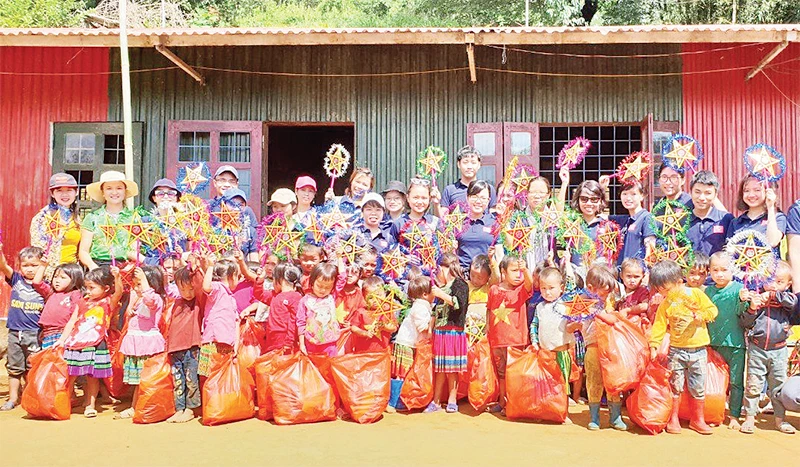 Thành viên dự án Đông ấm cho trẻ em vùng cao trao quà tặng học sinh tại một điểm trường ở xã Nậm Có, huyện Mù Cang Chải, tỉnh Yên Bái nhân dịp Tết Trung thu.