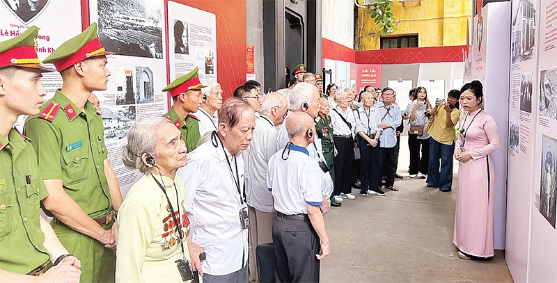 Các đại biểu tham quan trưng bày nghe giới thiệu về những cống hiến, hy sinh của các chiến sĩ cách mạng trong đấu tranh giải phóng dân tộc.