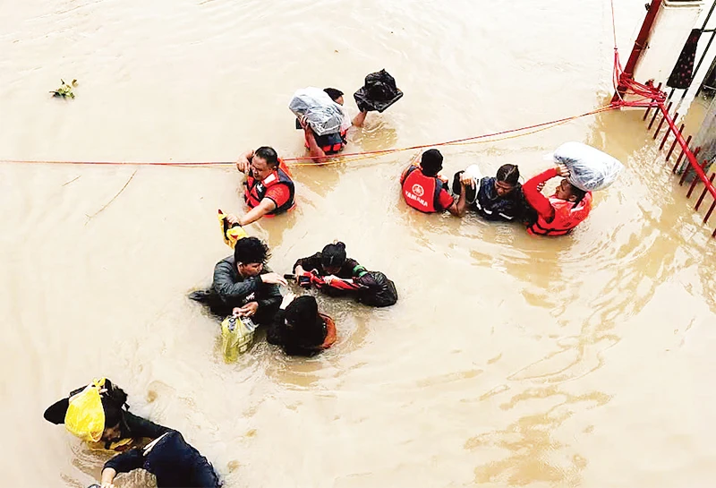 Hỗ trợ người dân sơ tán khỏi khu vực ngập lụt ở Philippines. (Ảnh REUTERS)