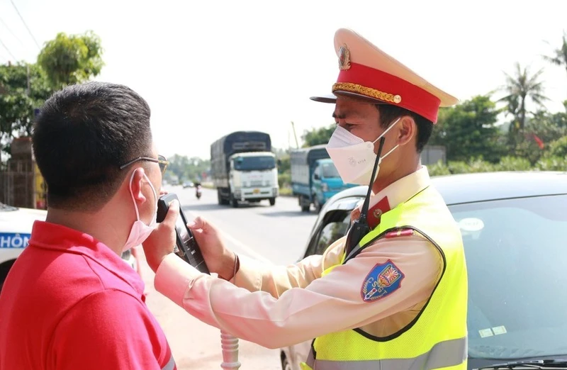 Lực lượng chức năng kiểm tra nồng độ cồn đối với người điều khiển phương tiện. (Ảnh: Đức Cường)